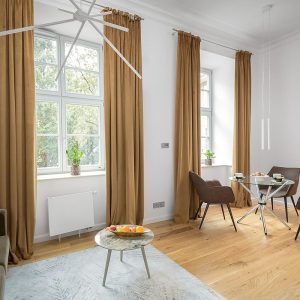 Salon z jadalnią i wysokimi oknami w kamienicy we Wrocławiu