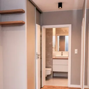 Szafa przesuwna na wymiar w korytarzu z drewnianymi półkami otwartymi, MTW Studio Wrocław