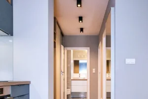 Kompleksowa realizacja mebli na wymiar – widok z kuchni na korytarz z szafą przesuwną i łazienką – mieszkanie 53 m², MTW Studio Wrocław