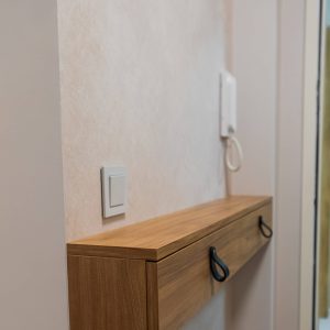Wąska drewniana półka z uchwytem na klucze w przedpokoju