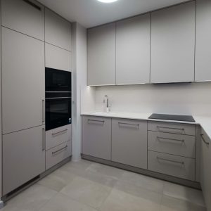 Matowe fronty greige bez uchwytów i piekarniki w wysokiej zabudowie kuchennej